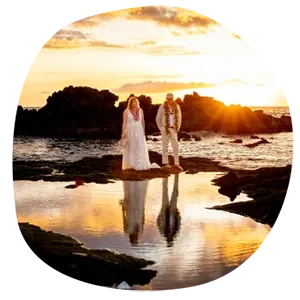 Dramatic silhouette of bride and groom with perfect water reflection during spectacular Hawaii sunset