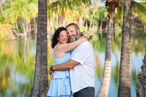 Couple embracing by serene tropical pond with lush green vegetation in Hawaii