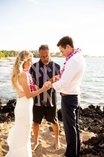 Wedding officiant performing traditional lei ceremony for couple in Hawaii